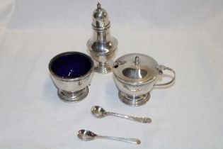 A silver three-piece cruet set comprising a baluster-shaped pepperette with domed cover,