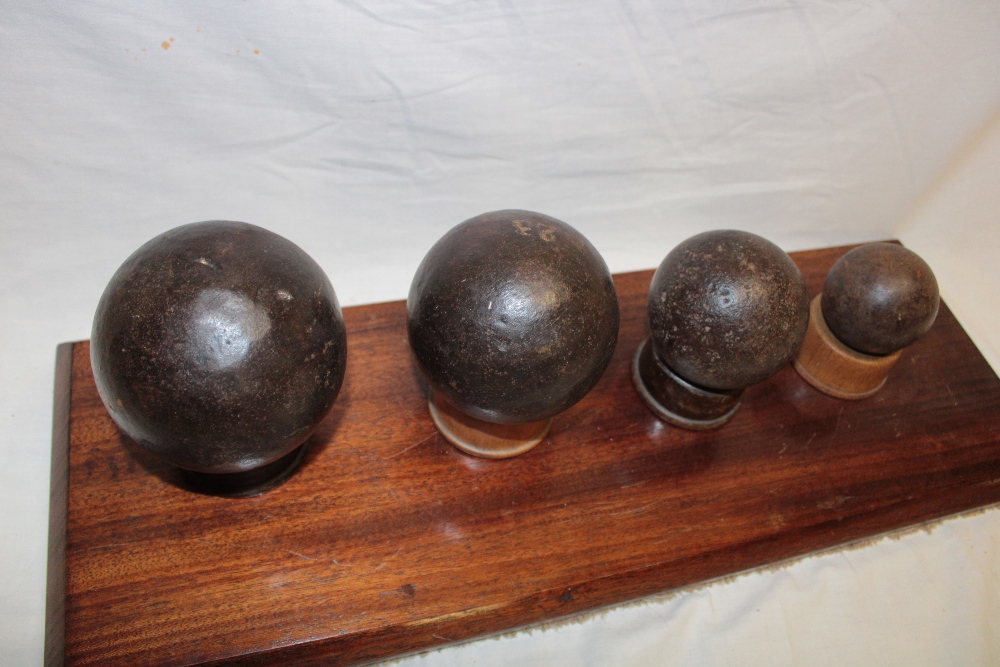 A display of four 18th and 19th century iron cannon balls, 4½" diameter - 2½" diameter, - Image 2 of 2