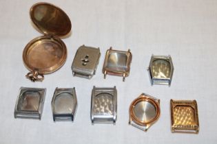 A selection of vintage watch cases and a gold plated pocket watch case