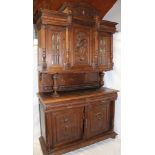A 19th century Continental carved oak side cabinet with two drawers in the frieze and cupboard