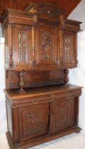 A 19th century Continental carved oak side cabinet with two drawers in the frieze and cupboard