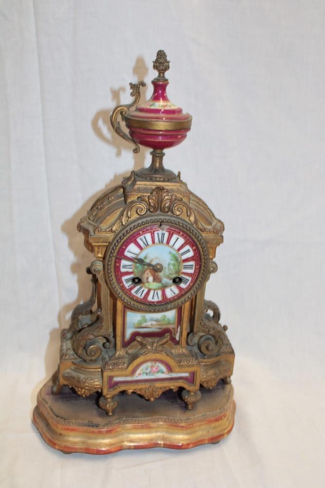 A 19th century Continental gilt spelter mantel clock with porcelain decorated dial and panels on