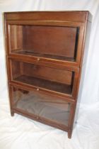 An oak three-tier sectional bookcase by Gunn with folding glazed fronts,