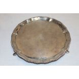 A George III silver circular waiter tray with decorated edge and engraved armorial crest on three