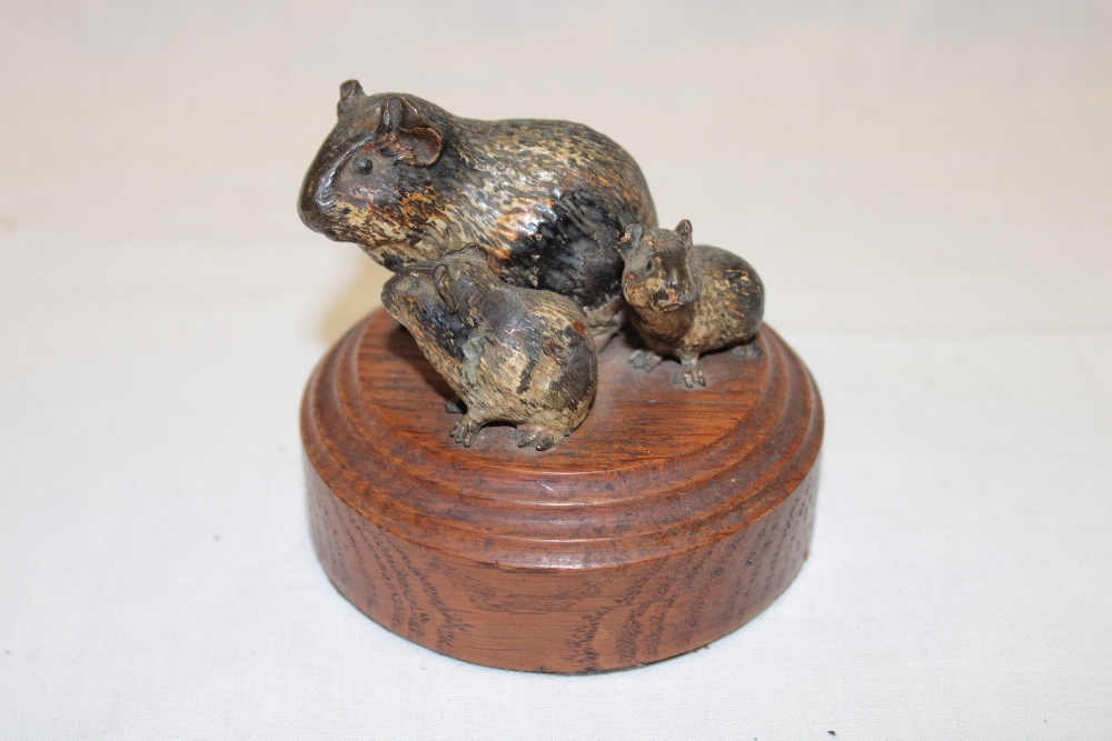 An Austrian painted bronze miniature figure of three rodents on turned wood base,
