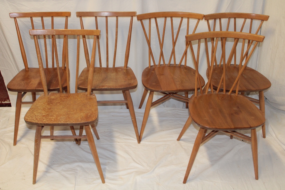 Three 1960's/70's Ercol pale elm dining chairs with crossed spindle-backs and shaped seats on