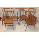 Three 1960's/70's Ercol pale elm dining chairs with crossed spindle-backs and shaped seats on