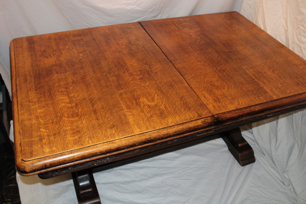 A 1930's oak rectangular draw-leaf refectory-style table with decorated frieze on carved supports - Image 2 of 2