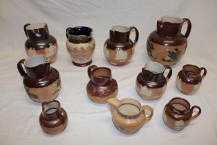 A selection of 19th century and later stoneware harvest jugs including Doulton Lambeth pottery