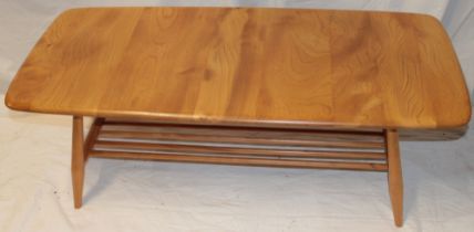 A 1960's/70's Ercol pale elm coffee table with magazine rack on tapered legs,