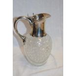 A George V cut-glass and silver mounted claret jug with silver handle and hinged top, 8½" high,