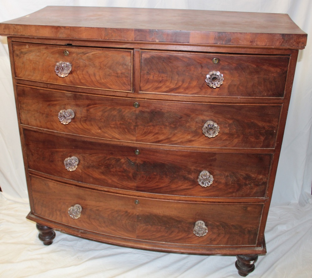 A Victorian mahogany bow front chest of two short and three long drawers with glass handles on