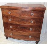 A Victorian mahogany bow front chest of two short and three long drawers with glass handles on