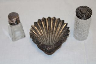 A silver scallop-shaped sweetmeat dish and two various silver topped glass dressing bottles (3)
