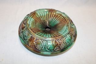 A 19th century majolica glazed circular spittoon with raised grape and leaf decoration,