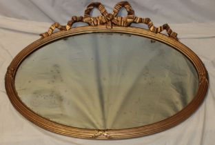 A 19th century oval wall mirror in gilt ribbon decorated frame,