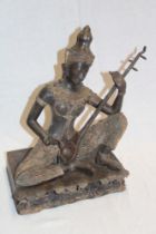 An Eastern bronze figure of a seated figure playing a sitar on rectangular base,