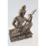 An Eastern bronze figure of a seated figure playing a sitar on rectangular base,