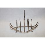 A late Victorian silver four section toast rack with loop handle on paw feet,