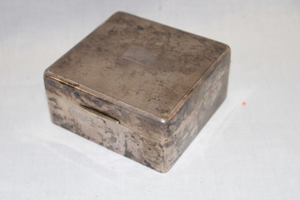 A George V silver square cigarette box with engine turned decoration,