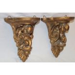 A pair of gilt plaster semi-circular wall plaques with cherub supports,