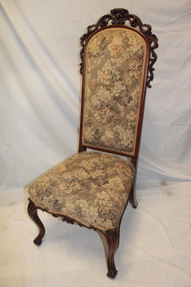 A Victorian carved mahogany hall chair upholstered in floral tapestry on scroll legs