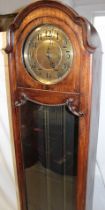 A 1920's/30's grandfather clock with brass circular dial in oak glazed arched traditional case