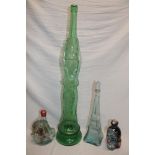 A large unusual green tinted glass commercial display bottle depicting a female with arms raised,