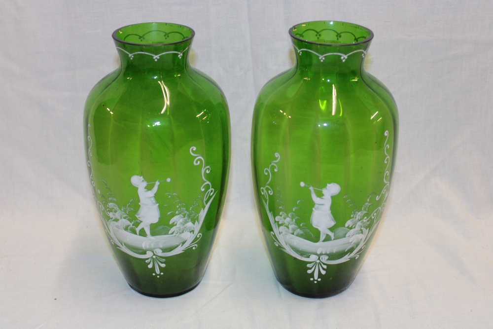 A pair of green tinted glass Mary Gregory-style tapered vases with young boy and girl decoration,