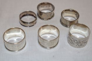 Two pairs of silver circular napkin rings with engraved decoration and two other silver napkin