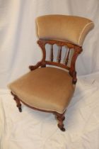 A late Victorian oak occasional chair with upholstered seat and back and turned tapered legs