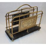 A Victorian brass twin-section magazine rack with panels decorated in relief with flowers on