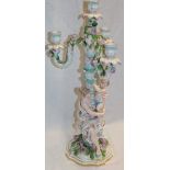 A German porcelain candelabrum with four ornamental candle sconces above a female and child