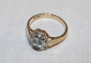 A 9ct gold dress ring set topaz surrounded by diamond chips (2.