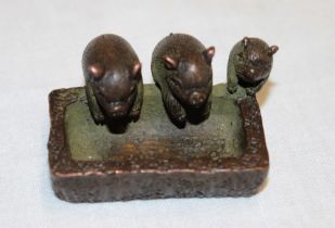 A miniature Chinese bronze figure of three pigs at a trough, signed,
