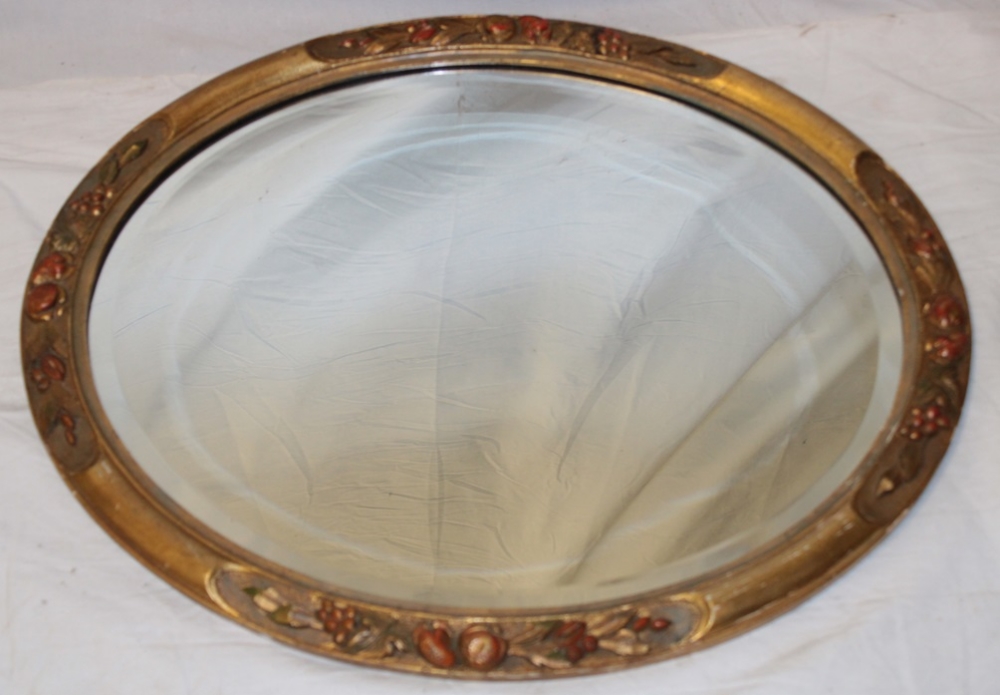 A good quality bevelled oval wall mirror in gilt and fruit decorated oval frame,