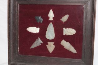 A display of Neolithic spearheads and arrowheads in glazed display frame