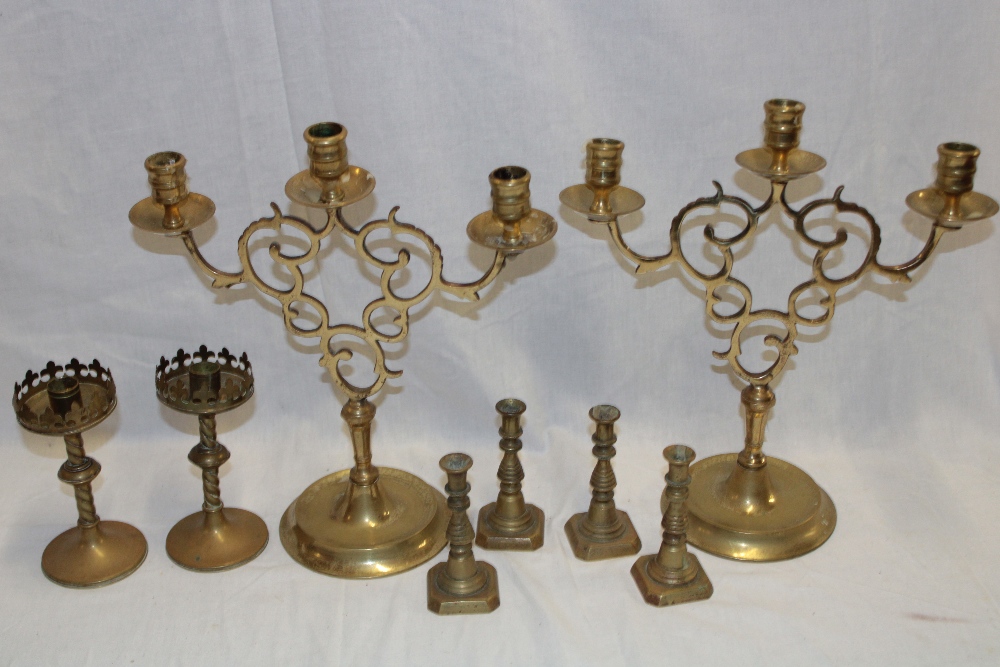 A pair of brass ornamental three branch candelabra with pierced decorated stems, 13" high,