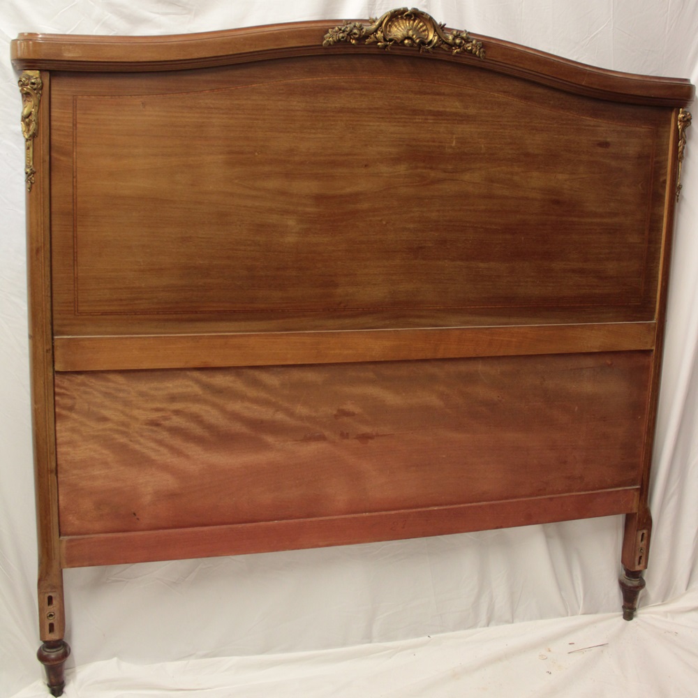 A 19th century French inlaid walnut double bed with raised brass scroll mounts,