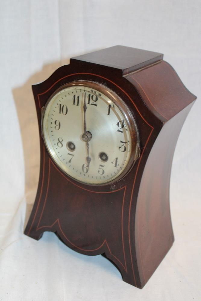 An Art Nouveau-style mantel clock with silvered circular dial in inlaid mahogany case