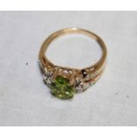 A 9ct gold dress ring set a green stone surrounded by diamonds (3.