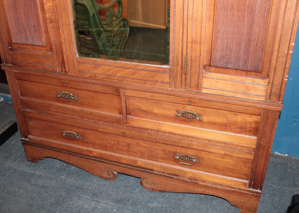 A Victorian walnut wardrobe with hanging compartment enclosed by a central mirror panel door above - Image 3 of 3