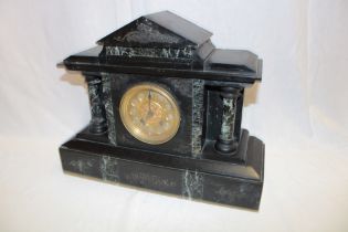 A Victorian mantel clock with gilt circular dial in black slate and marble traditional case