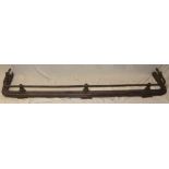 A large Victorian iron and oxidised metal fire fender with rope-twist decorated rail,