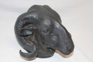 An old cast metal wall plaque in the form of a ram's head with horns,