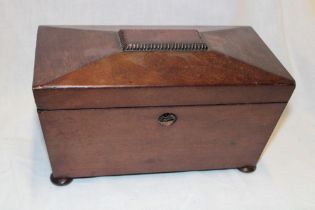 A 19th century mahogany sarcophagus-shaped tea caddy with twin fitted interior
