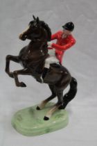 A Beswick china figure of a huntsman on a rearing brown horse,