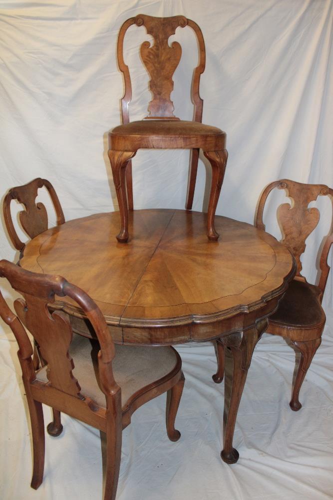 A 1920/30s walnut dining suite comprising a circular figured walnut dining table on cabriole legs,
