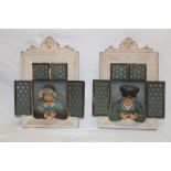 A pair of Continental pottery wall plaques depicting an elderly lady and gentleman peering from