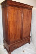 A late Victorian figured mahogany wardrobe with hanging compartment enclosed by two panelled doors